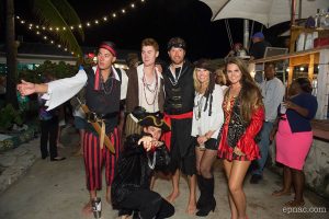 A group of people in pirate costumes posing for a photo at Staniel Cay in The Bahamas.