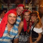 A group of people in pirate costumes posing for a photo at Staniel Cay Yacht Club in The Bahamas.