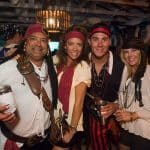 A group of people dressed as pirates pose for a photo at the Staniel Cay Yacht Club in The Bahamas.