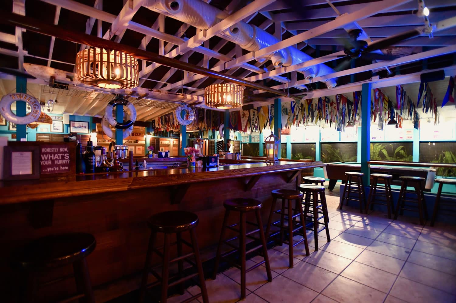 A bar with stools and a blue ceiling at Staniel Cay Yacht Club in The Bahamas.