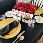 A elegant table setting with black roses and a luxurious gold box at the Staniel Cay Yacht Club.