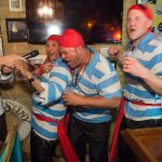 A group of men dressed as pirates enjoy a lively evening in a bar while on vacation in Staniel Cay, The Bahamas.