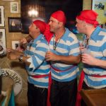 A group of men dressed as pirates gather at the Staniel Cay Yacht Club bar.