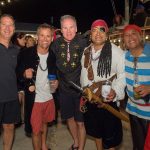 A group of men in pirate costumes posing for a photo at Staniel Cay Yacht Club in The Bahamas.