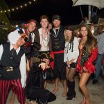 A group of people dressed in pirate costumes posing for a photo at Staniel Cay Yacht Club.