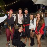 A group of people in pirate costumes at Staniel Cay Yacht Club, posing for a photo during their vacation in The Bahamas.