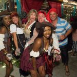 A group of people in pirate costumes posing for a photo at Staniel Cay Yacht Club.