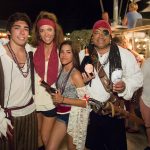 A group of people in pirate costumes posing for a photo at Staniel Cay Yacht Club in The Bahamas.