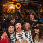 A group of people in pirate costumes posing for a photo at Staniel Cay Yacht Club, The Bahamas.