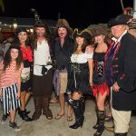 A group of people in pirate costumes posing for a photo at the Staniel Cay Yacht Club.