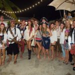 A group of people in pirate costumes posing for a photo during their vacation at the Staniel Cay Yacht Club in The Bahamas.