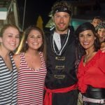 A group of people posing for a photo in pirate costumes at Staniel Cay Yacht Club.