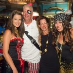 A group of people posing for a photo in pirate costumes at the Staniel Cay Yacht Club in The Bahamas.