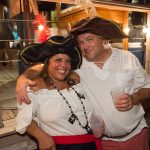 A man and woman wearing pirate hats pose for a photo in Staniel Cay, The Bahamas.