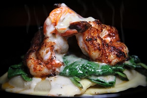 A plate of pasta with shrimp and spinach on top, served at Staniel Cay Yacht Club.