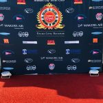 A red carpet adorned with the Staniel Cay Vacation Rentals and Staniel Cay Yacht Club logos.