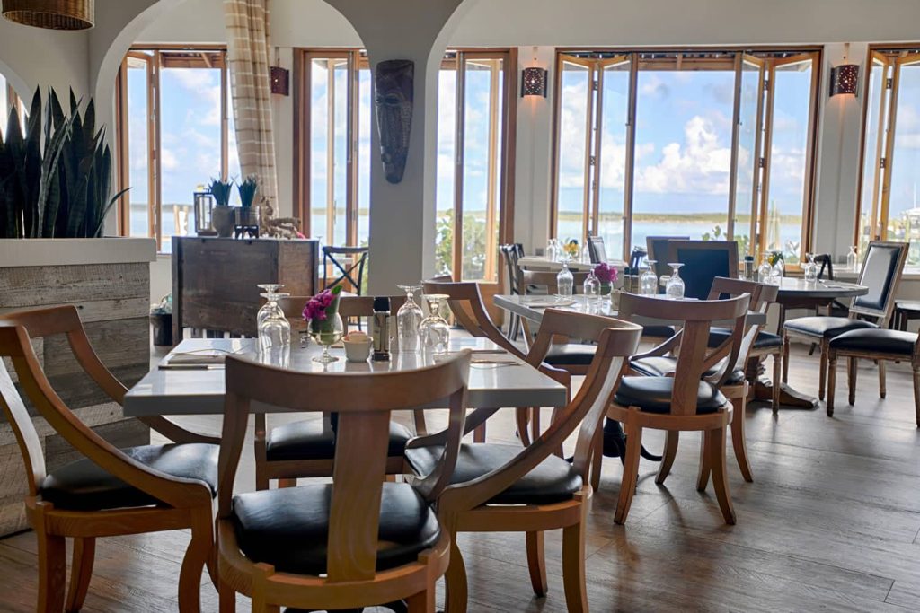 A restaurant with large windows overlooking the ocean in The Bahamas.