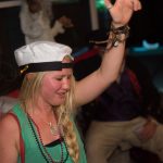 A woman wearing a pirate hat and dancing at the Staniel Cay Yacht Club in The Bahamas.