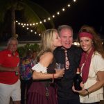 At the Staniel Cay Yacht Club, a woman in a pirate costume playfully kisses a man at a party.