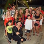 Excited vacationers at Staniel Cay Yacht Club posing in pirate costumes for a memorable photo.