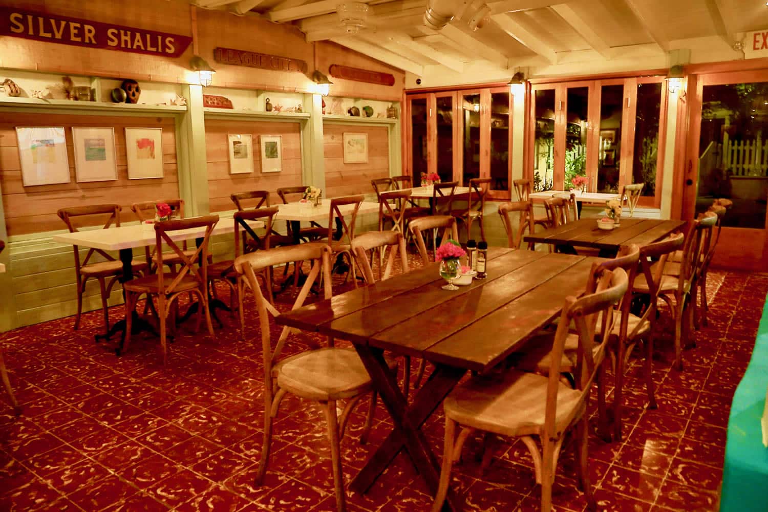 The interior of a restaurant in Staniel Cay Yacht Club with tables and chairs.