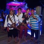 Three men dressed as pirates standing on a dock in The Bahamas.