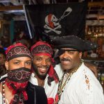 Three men in pirate costumes posing for a photo at Staniel Cay Yacht Club.