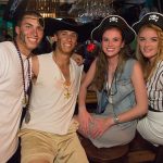 Three people in pirate hats posing for a photo at the Staniel Cay Yacht Club bar in The Bahamas.