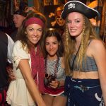 Three women in pirate costumes pose for a photo at a party in The Bahamas.