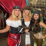 Three women in pirate costumes posing for a photo at Staniel Cay Yacht Club.