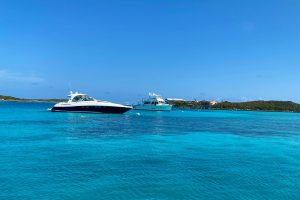Two boats anchored in the clear blue water near Staniel Cay Yacht Club.