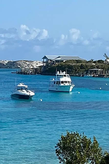 Two boats docked near a small island in Staniel Cay.