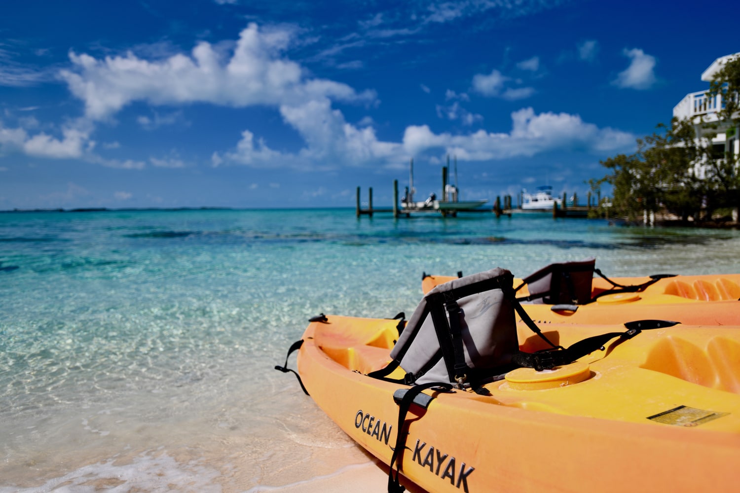 Two orange kayaks on a sandy beach at Staniel Cay in The Bahamas, near the Staniel Cay Yacht Club.