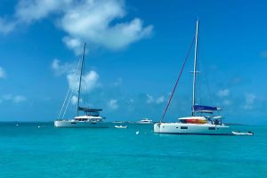 Two sailboats moored in the clear blue water near Staniel Cay Yacht Club.