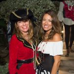 Two women in pirate costumes posing for a photo during their vacation at the Bahamas.