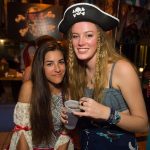 Two women in pirate hats posing for a photo at the Staniel Cay Yacht Club in The Bahamas.