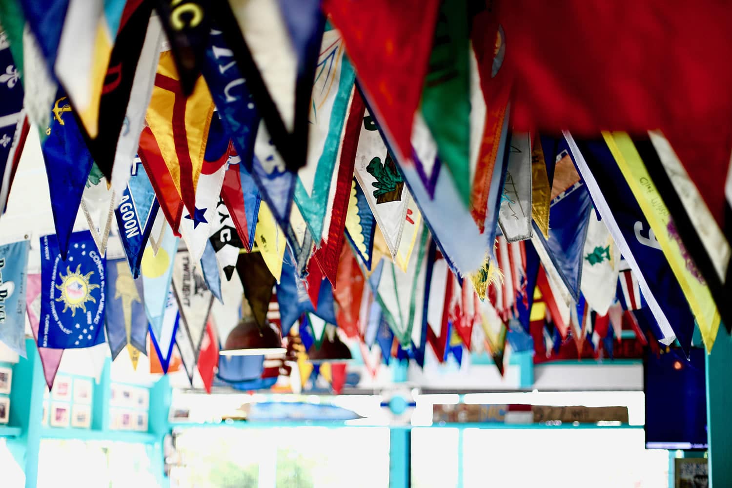 Vibrant flags hanging from the ceiling of a Staniel Cay restaurant.