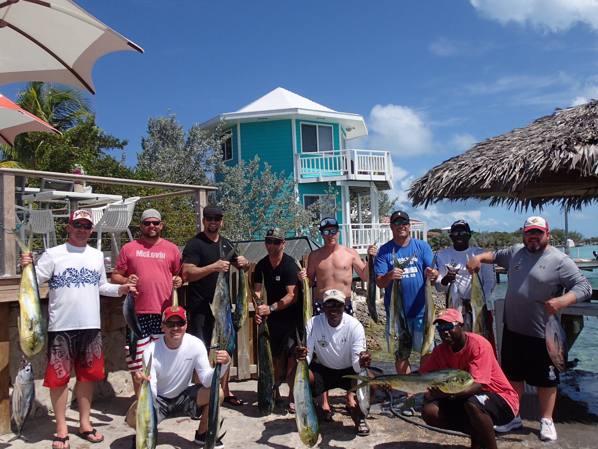 A group of men at Staniel Cay Yacht Club posing for a photo.