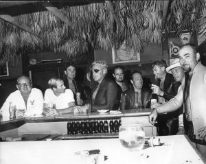 A group of men standing around a bar at Staniel Cay Yacht Club.