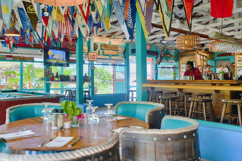 The interior of a restaurant in Staniel Cay with flags hanging from the ceiling.