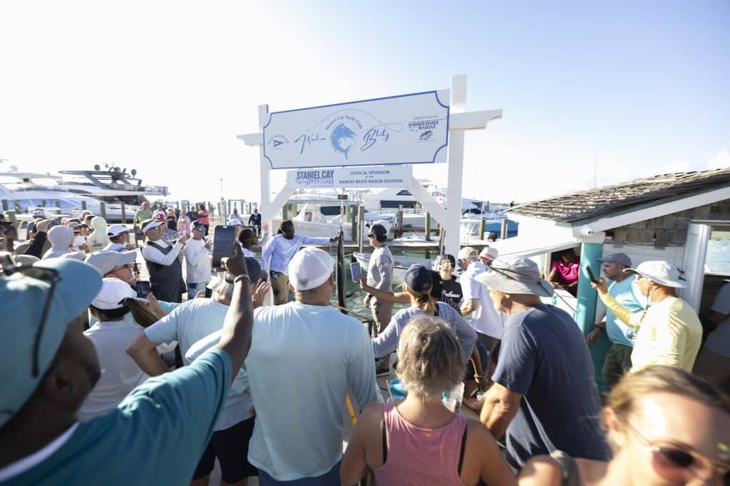 Staniel Cay Yacht Club A crowd gathers at a dock under a sign for the SCYC Wahoo Blitz fishing tournament. Vacation Rentals and Resort on Staniel Cay Exuma
